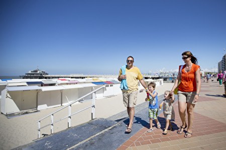 Sommerliche Familie mit Kindern spaziert entlang des Seedeichs.