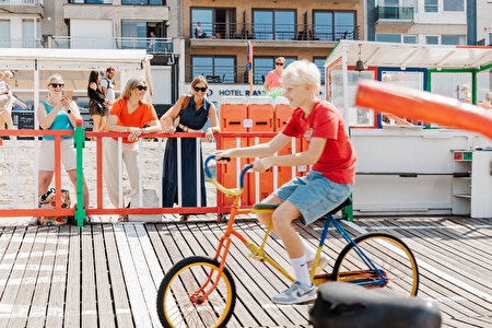 Art von verrücktem Fahrrad, während Damen zusehen.